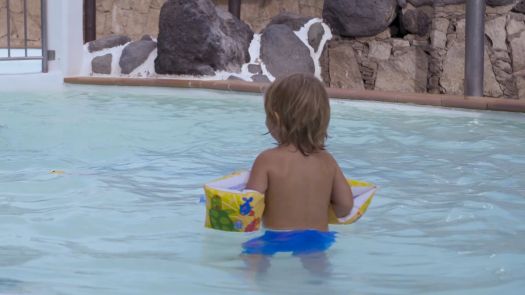 A child in a swimming pool without supervision, image from the Canary Islands drowning-prevention campaign